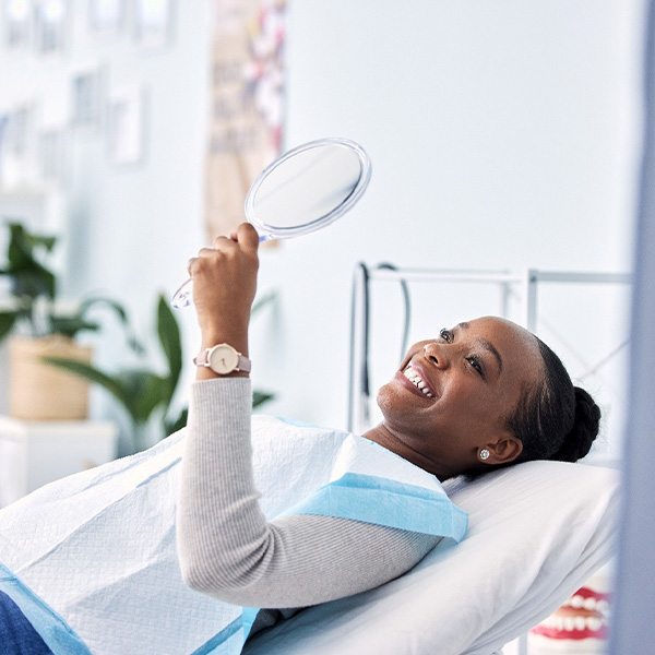 Woman smiling while looking at reflection in mirror