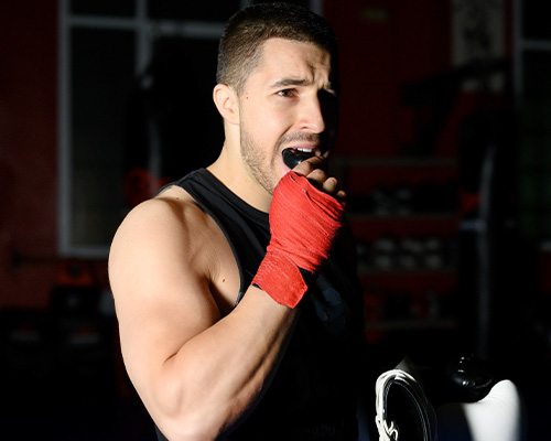 Man putting on mouthguard before workout