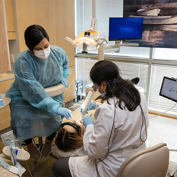 Dentist using intraoral camera to examine patients mouth