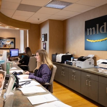 Woman sitting at front desk of dental office