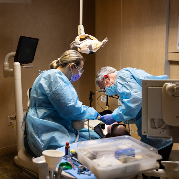 Dentists with masks performing a full mouth reconstruction