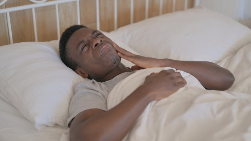 man in bed with a toothache