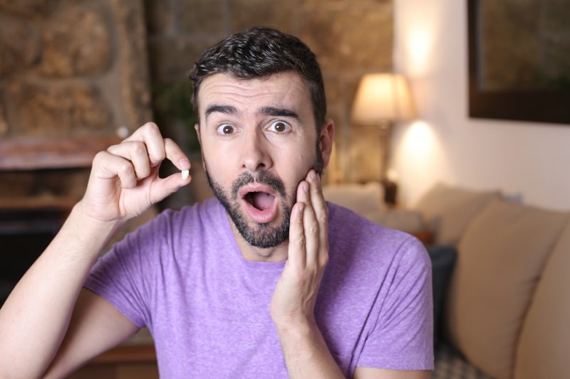 Patient rubbing their cheek due to knocked-out teeth